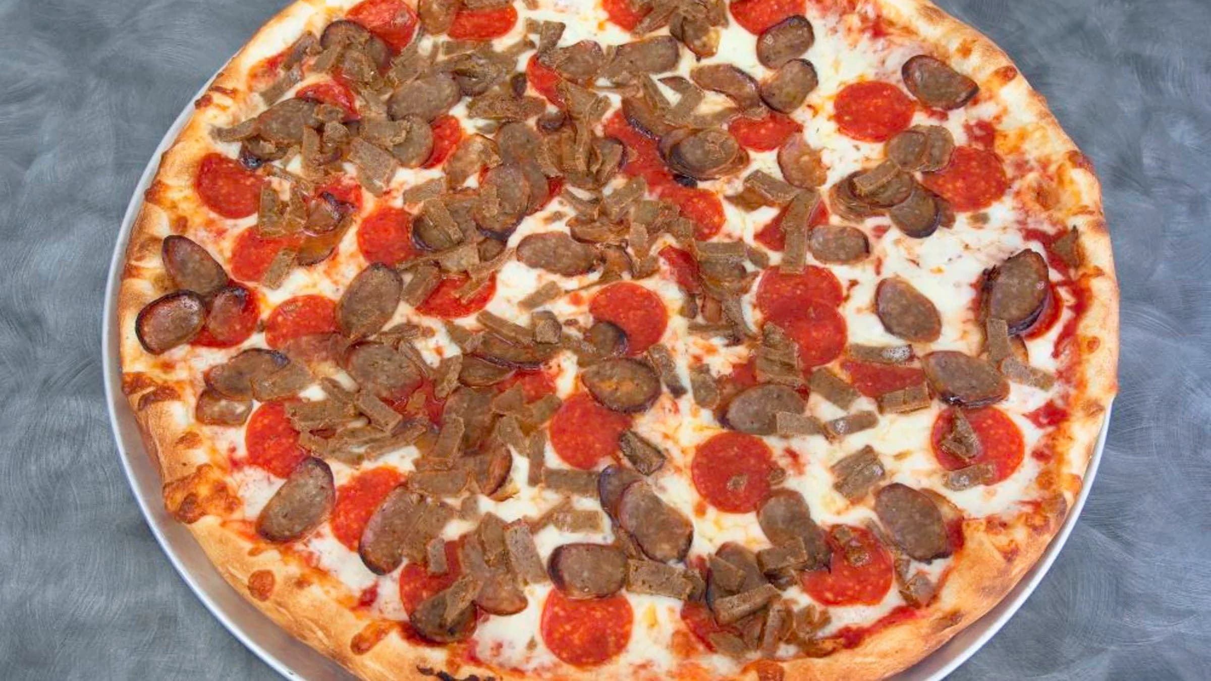 Meat lovers pizza with pepperoni and sausage fresh from the oven at San Pedro Pizza in the Bronx